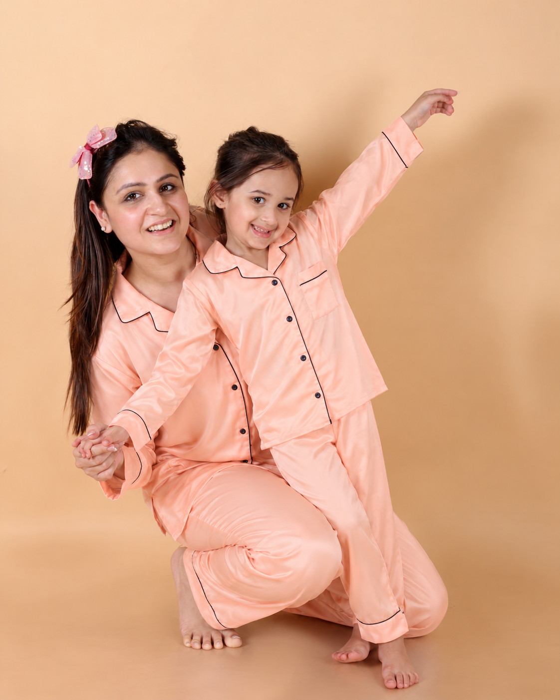 Mom and baby matching peach Shamoz silk pajamas, studio portrait